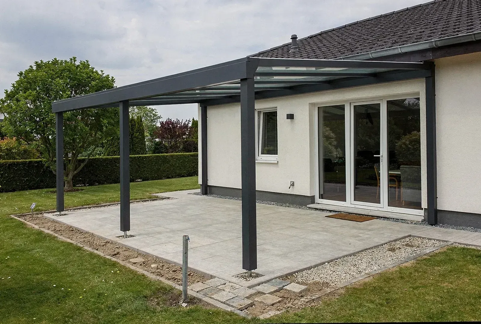 Monteure setzen eine Glasscheibe in ein Terrassendach in Flensburg